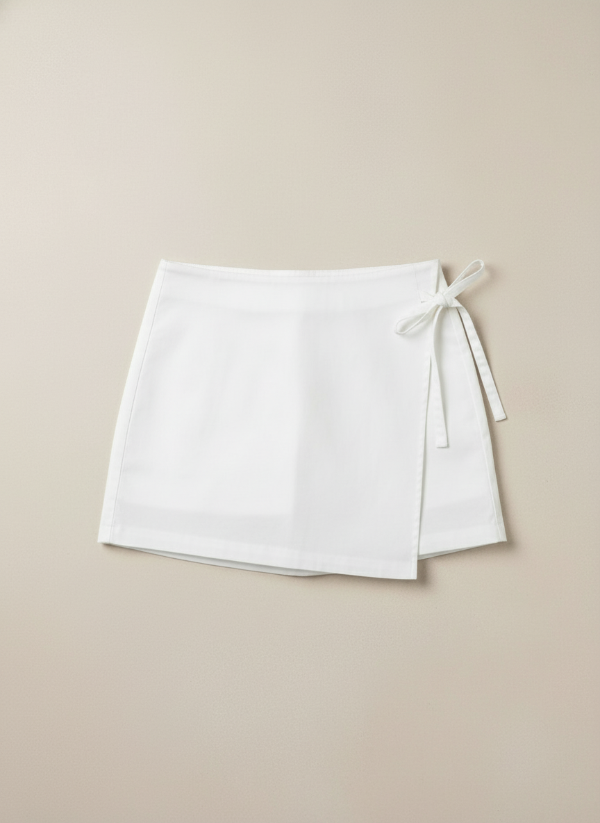 White skirt flat lay with bow on right